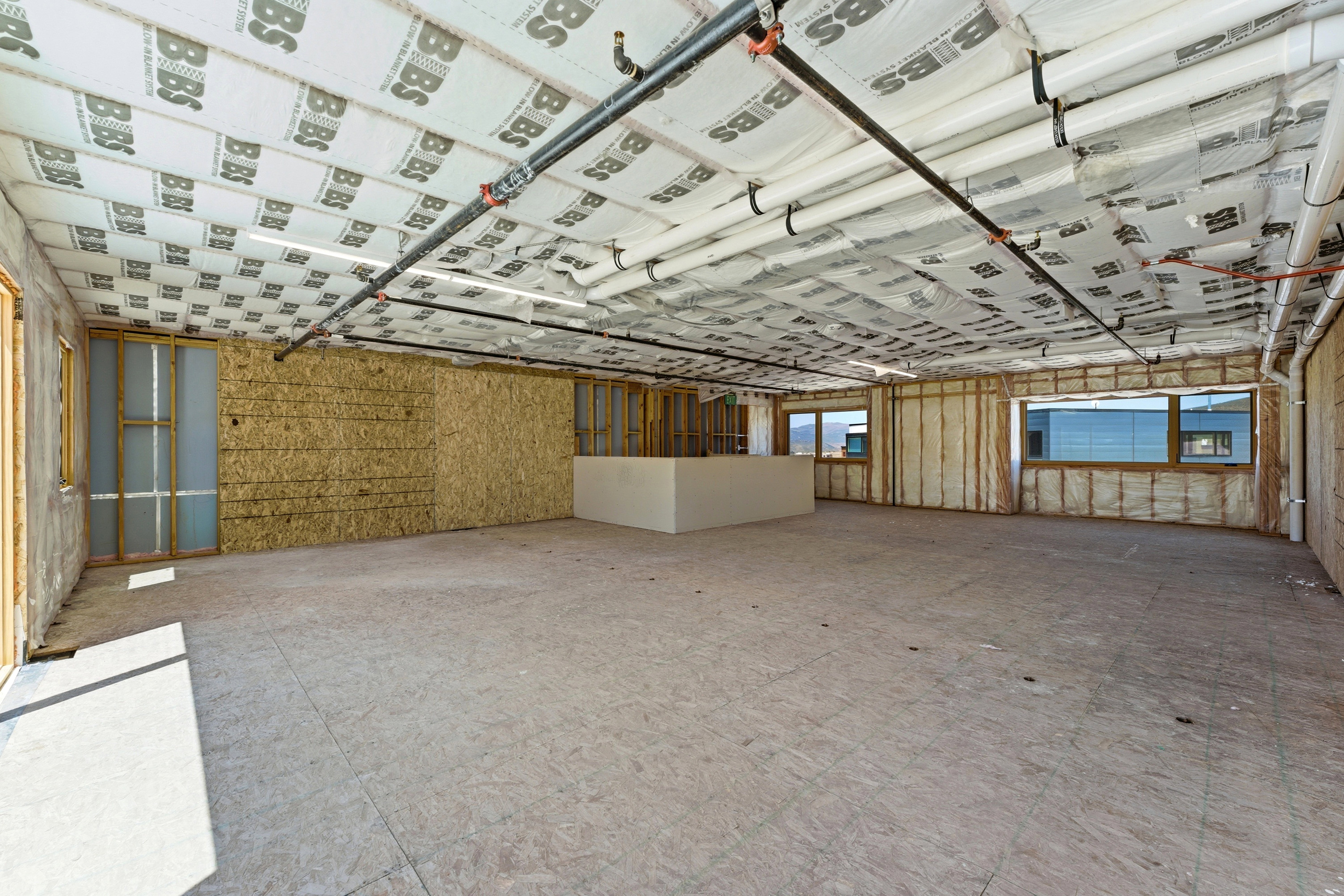Unfinished interior space featuring exposed ceiling insulation and visible plumbing lines