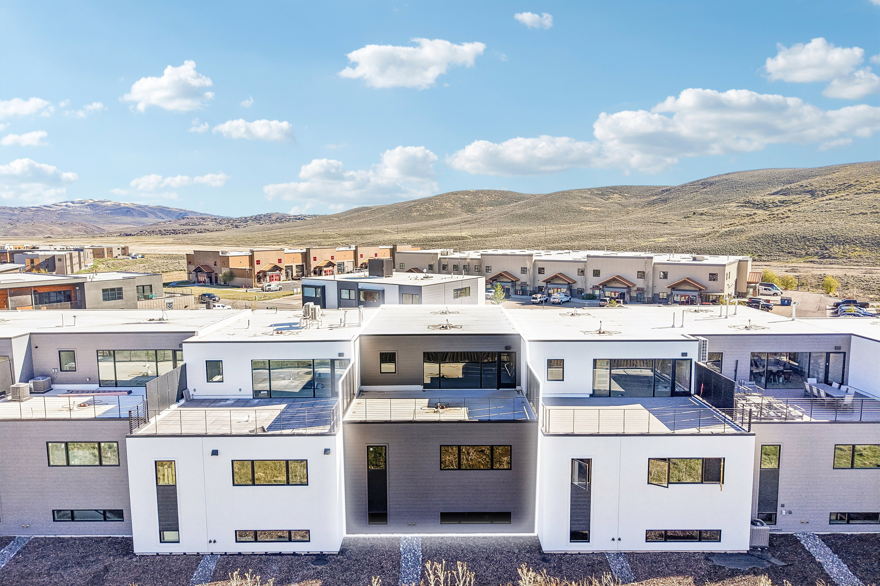 Contemporary flat-roof architecture featuring expansive windows and multiple rooftop deck spaces