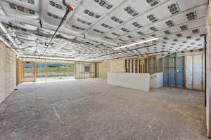 Expansive unfinished interior with concrete flooring and exposed ceiling insulation