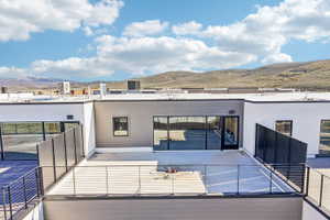 Rooftop patio featuring modern cable railings and direct access to an interior space via a glass panel door