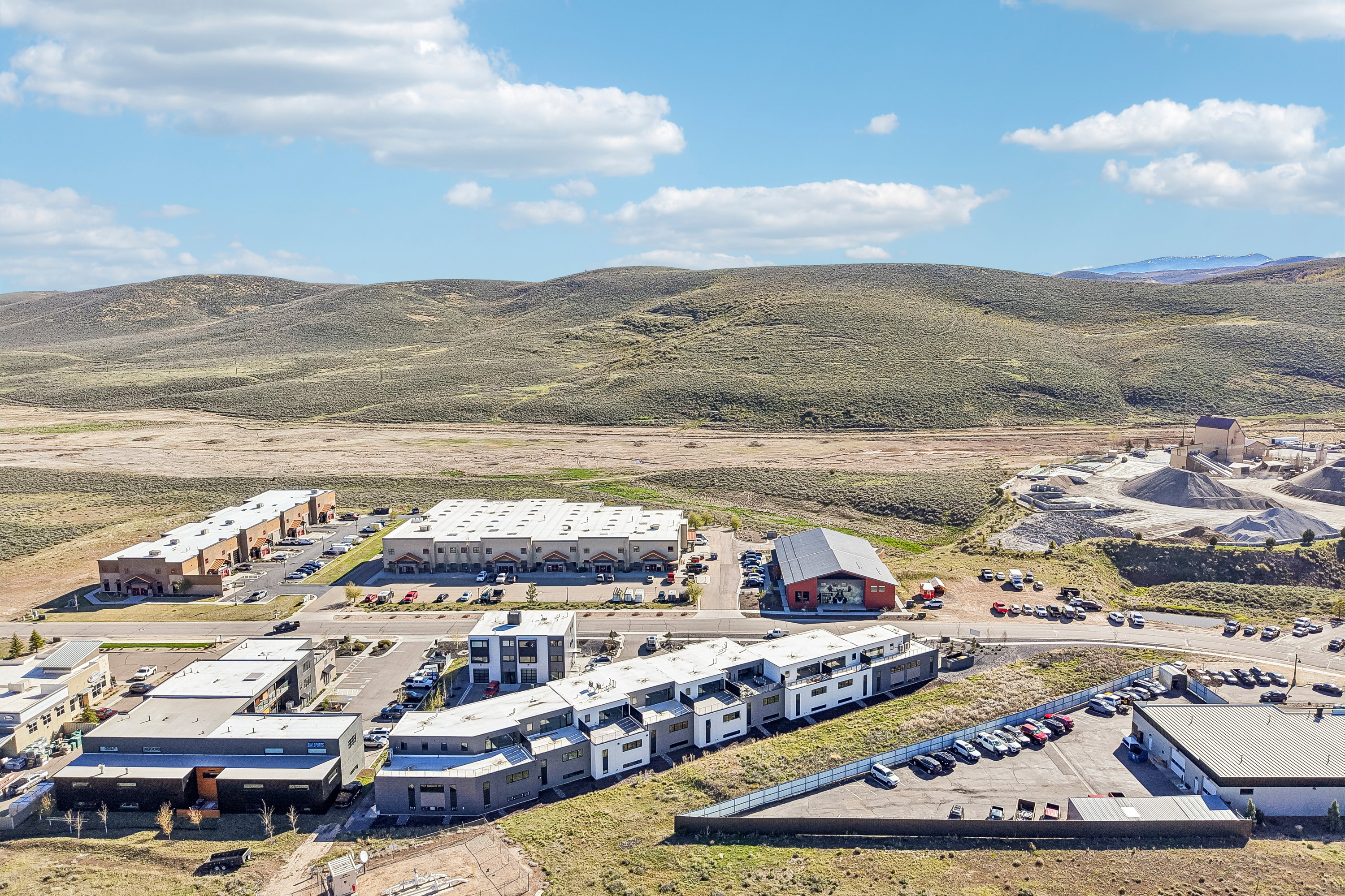 Aerial perspective showcasing diverse commercial and residential structures amidst natural terrain