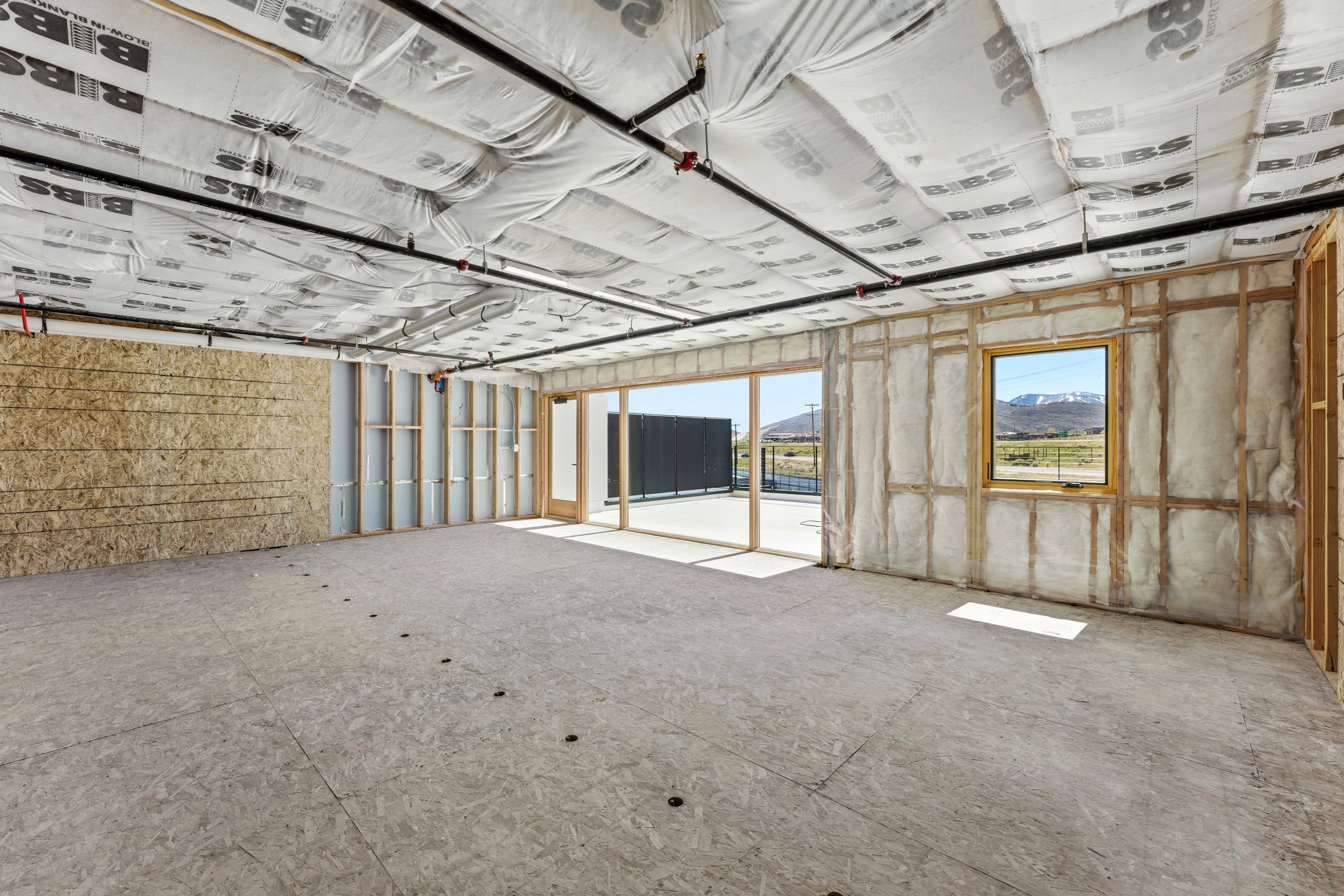Spacious interior with exposed wood framing and ceiling insulation