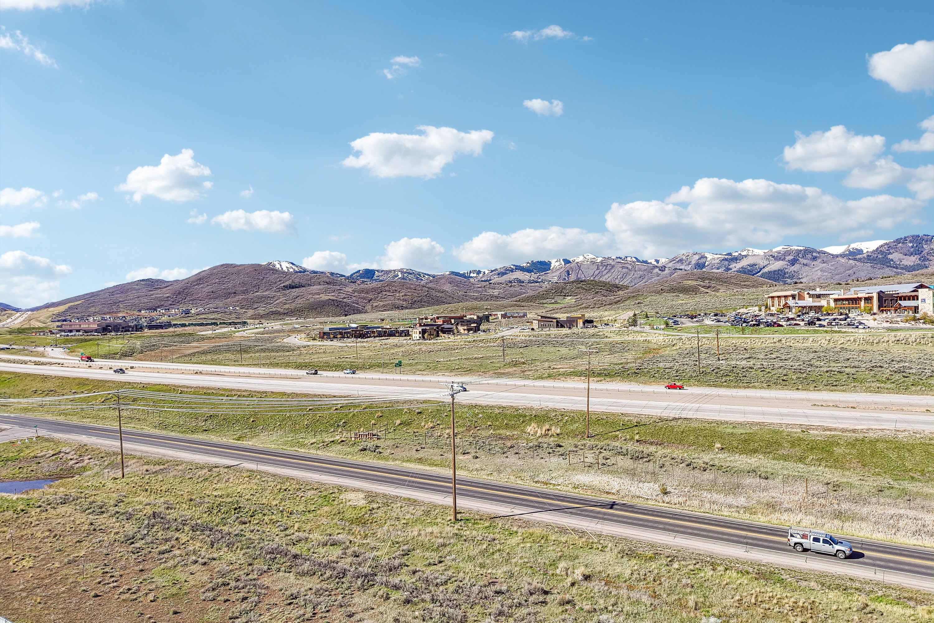 Expansive rural terrain with a highway and distant mountainous backdrop