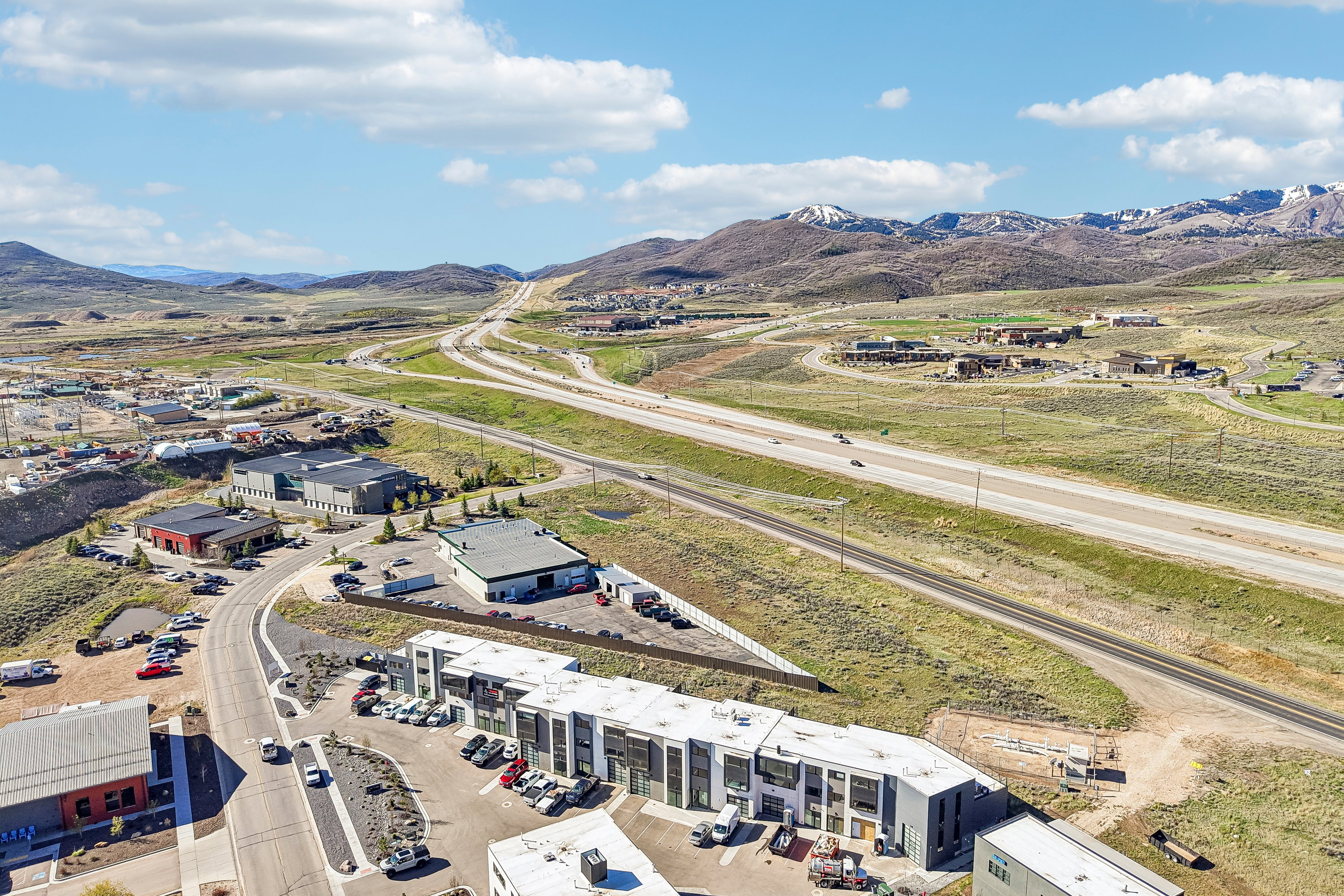 Aerial perspective showcasing multiple commercial buildings and a modern multi-unit structure