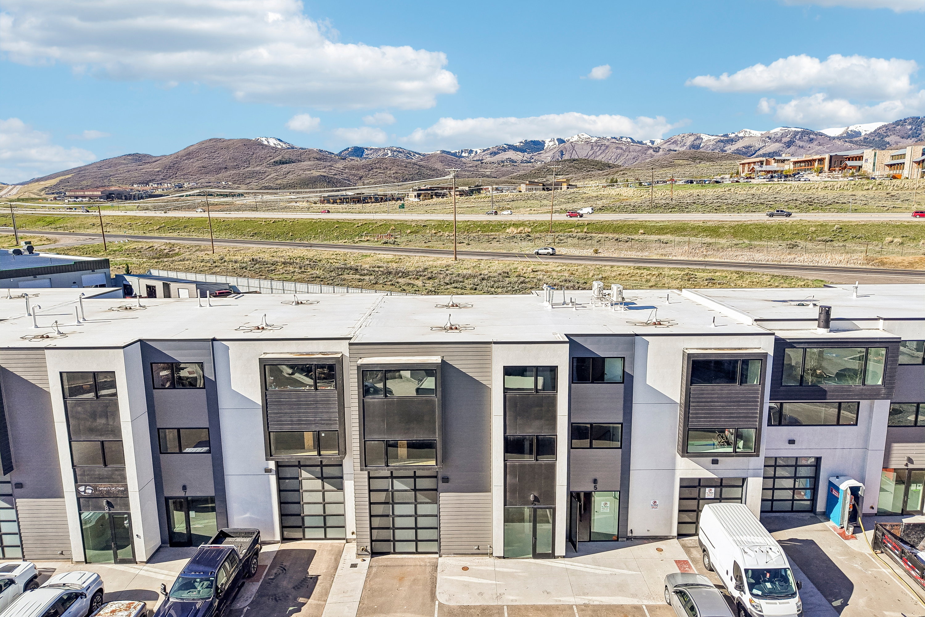 Contemporary multi-story buildings featuring a flat roofline and dark-framed windows