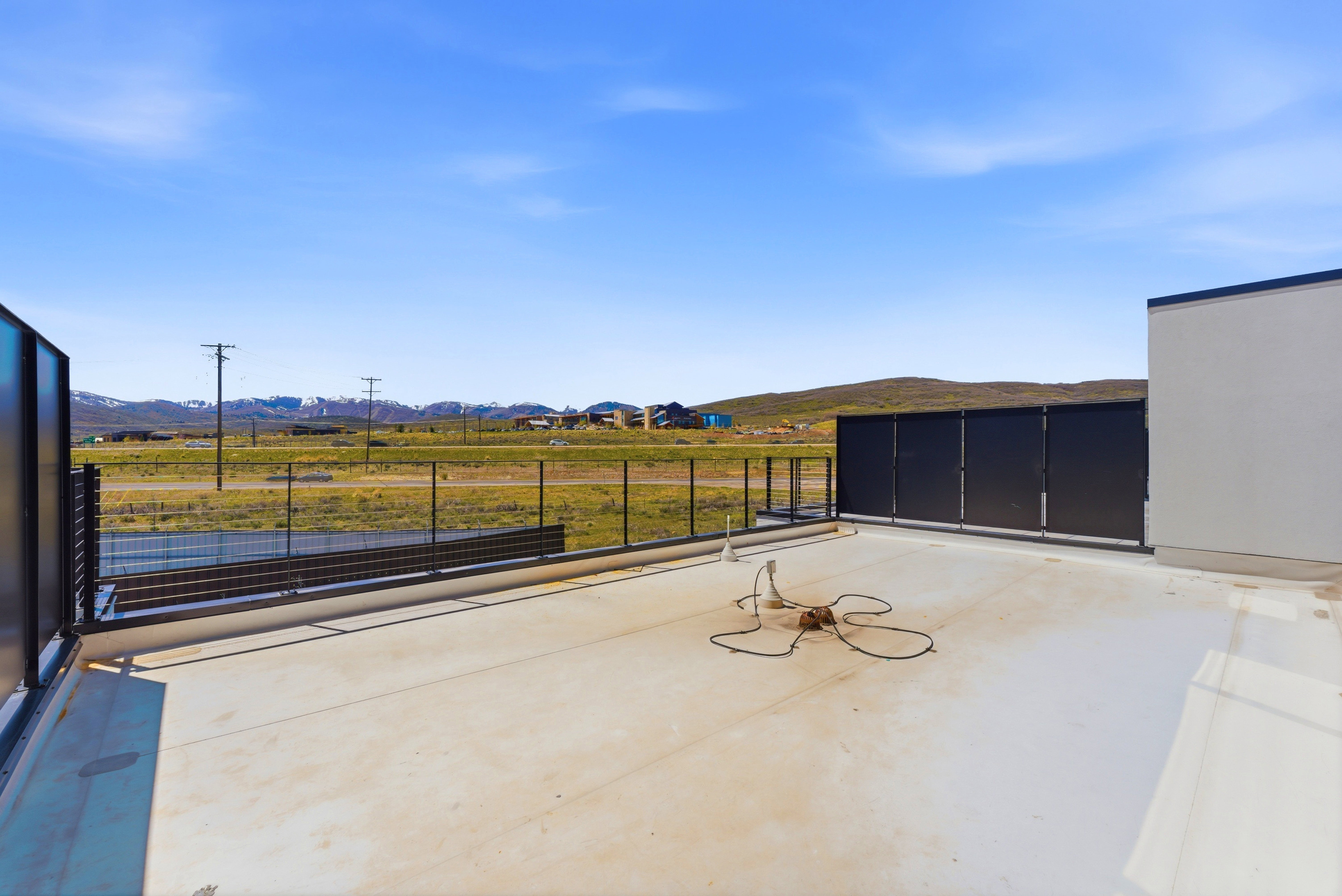 Expansive outdoor deck featuring a clear railing system and distant mountain scenery