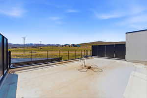 Expansive outdoor deck featuring a clear railing system and distant mountain scenery