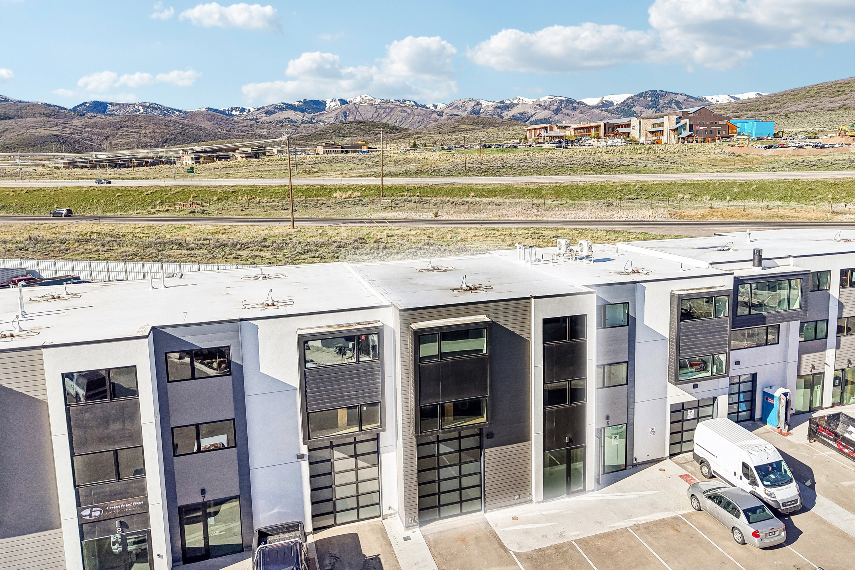 Modern multi-story building featuring a flat roofline and integrated garage doors