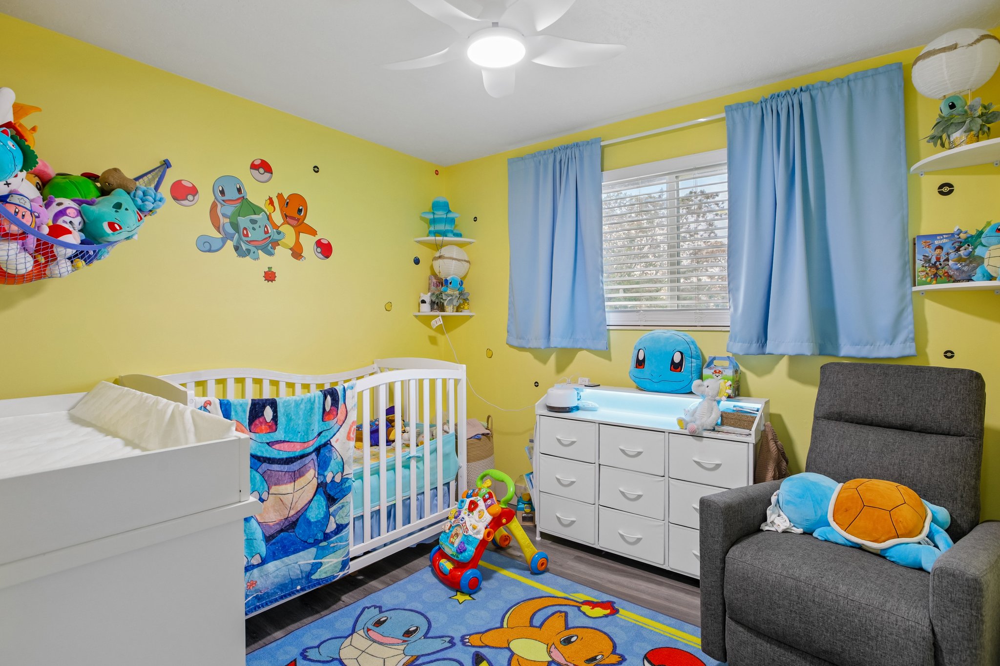 Bedroom featuring wood-finish flooring, a ceiling fan, and two windows with blinds