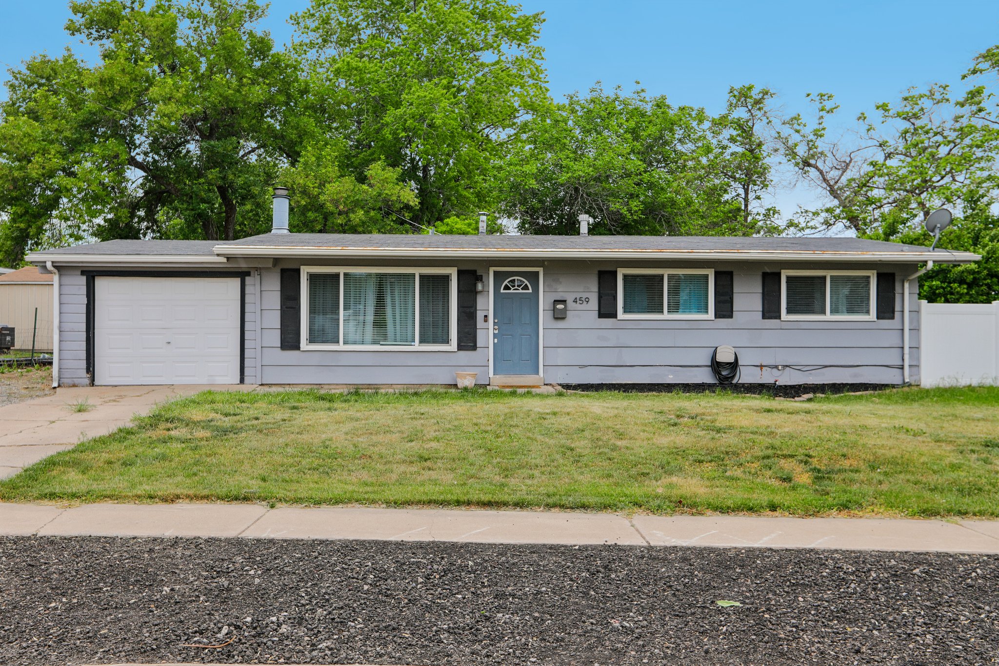 Ranch-style exterior with light gray siding, white trim, and a blue entry door