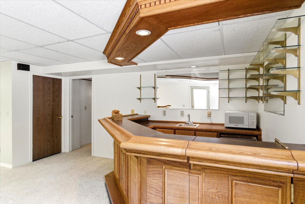 Custom bar area featuring a wood-finish bar, integrated sink, and ample counter space