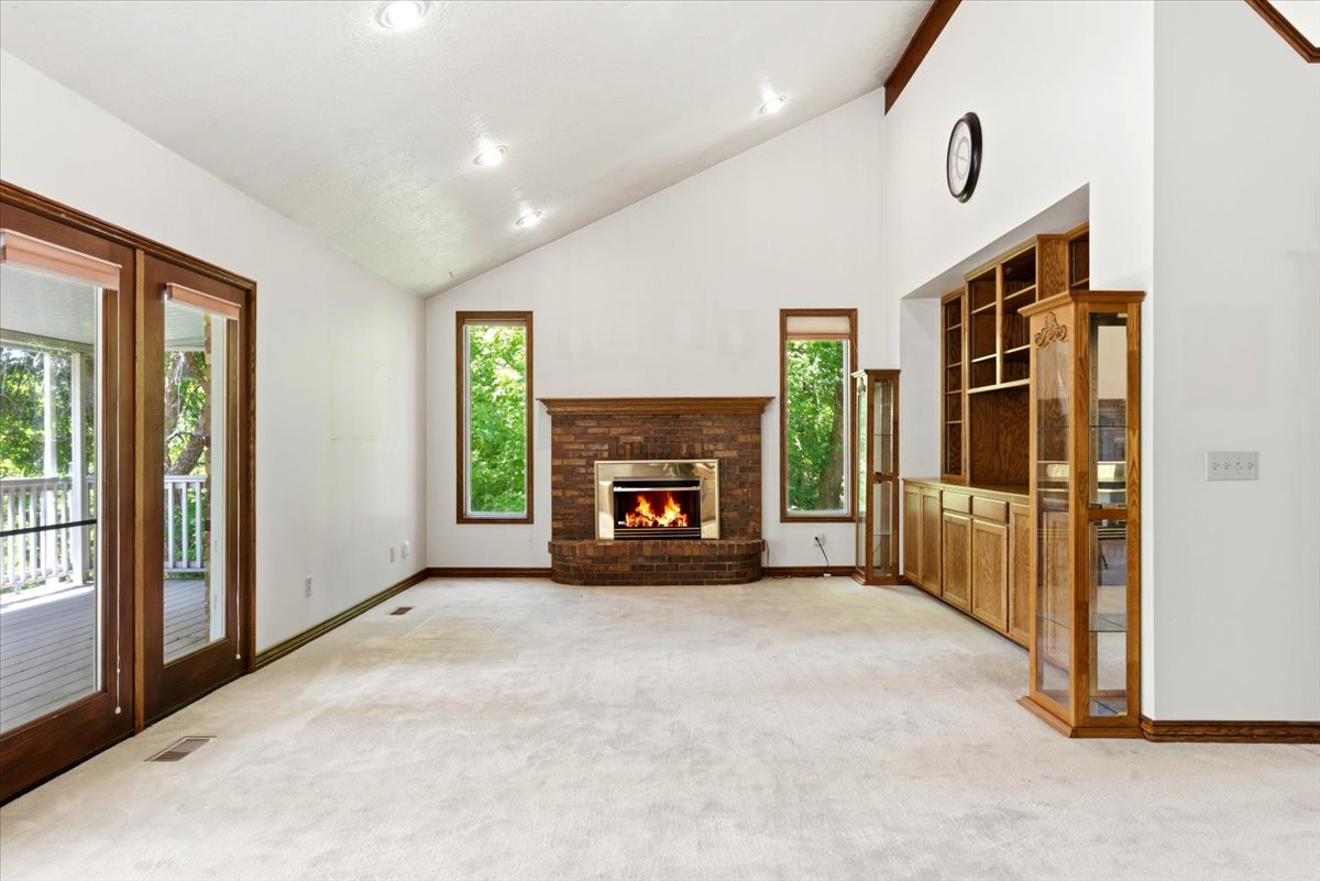 Spacious room featuring a vaulted ceiling and recessed lighting