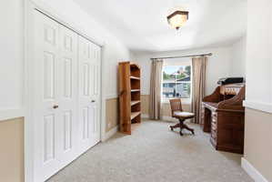 Room featuring neutral carpeting, a window with exterior views, and a ceiling-mounted light fixture