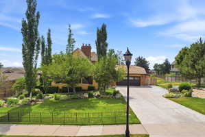 Residence featuring a cedar shake roof, brick chimney, and stucco exterior