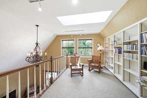 Upper-level landing featuring a large skylight, recessed lighting, and wall-to-wall carpeting