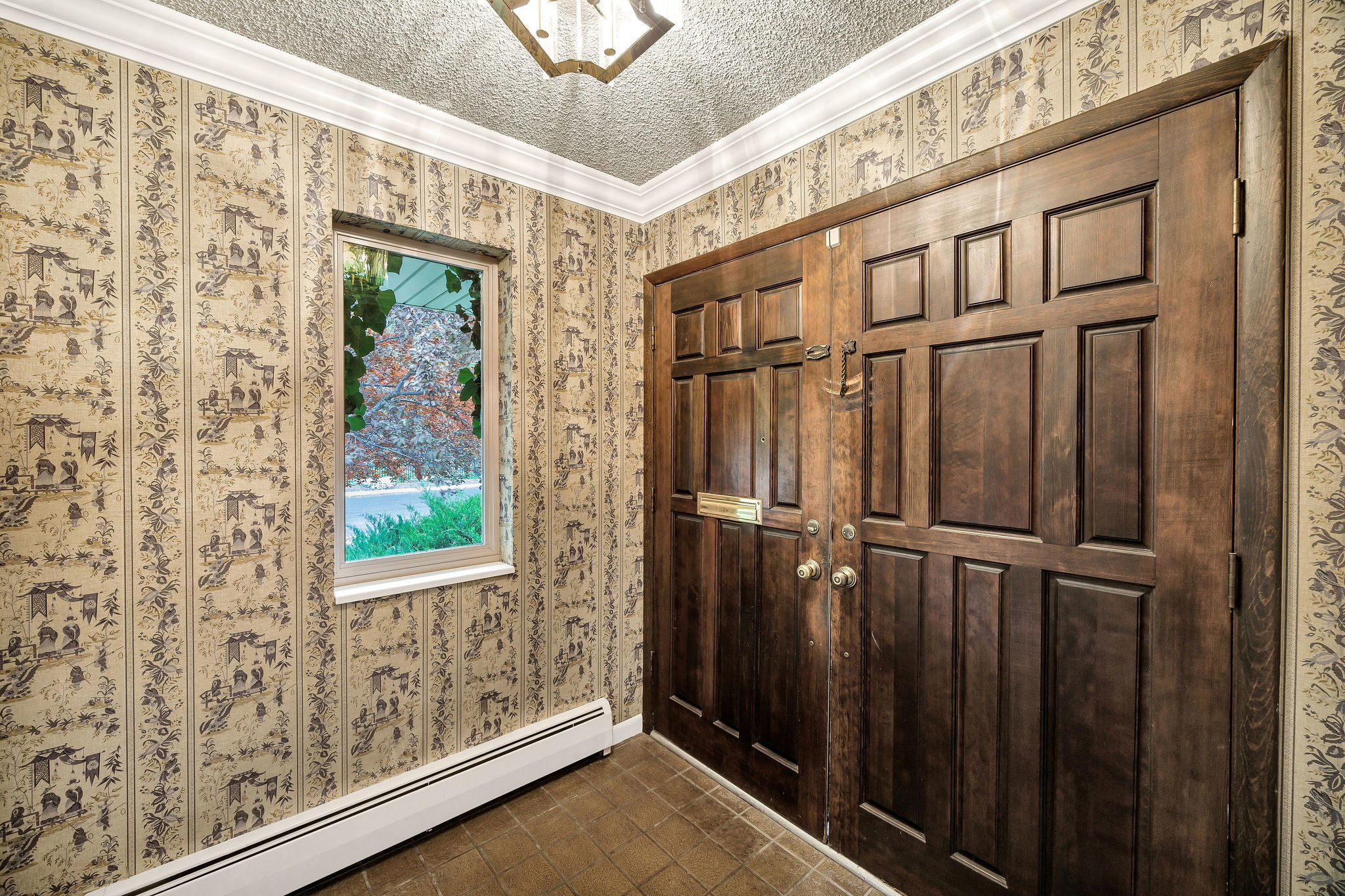 Double entry doors with panel details, a decorative ceiling fixture, and a single-pane window
