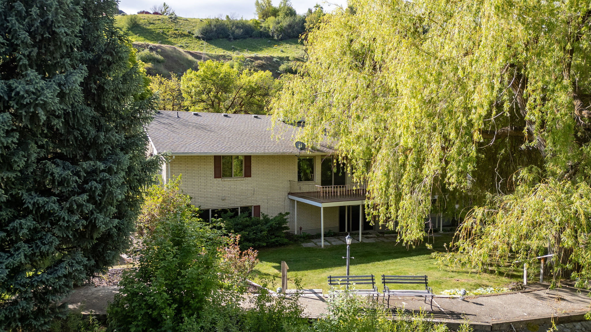 Rear exterior with a second-story balcony and ground-level patio