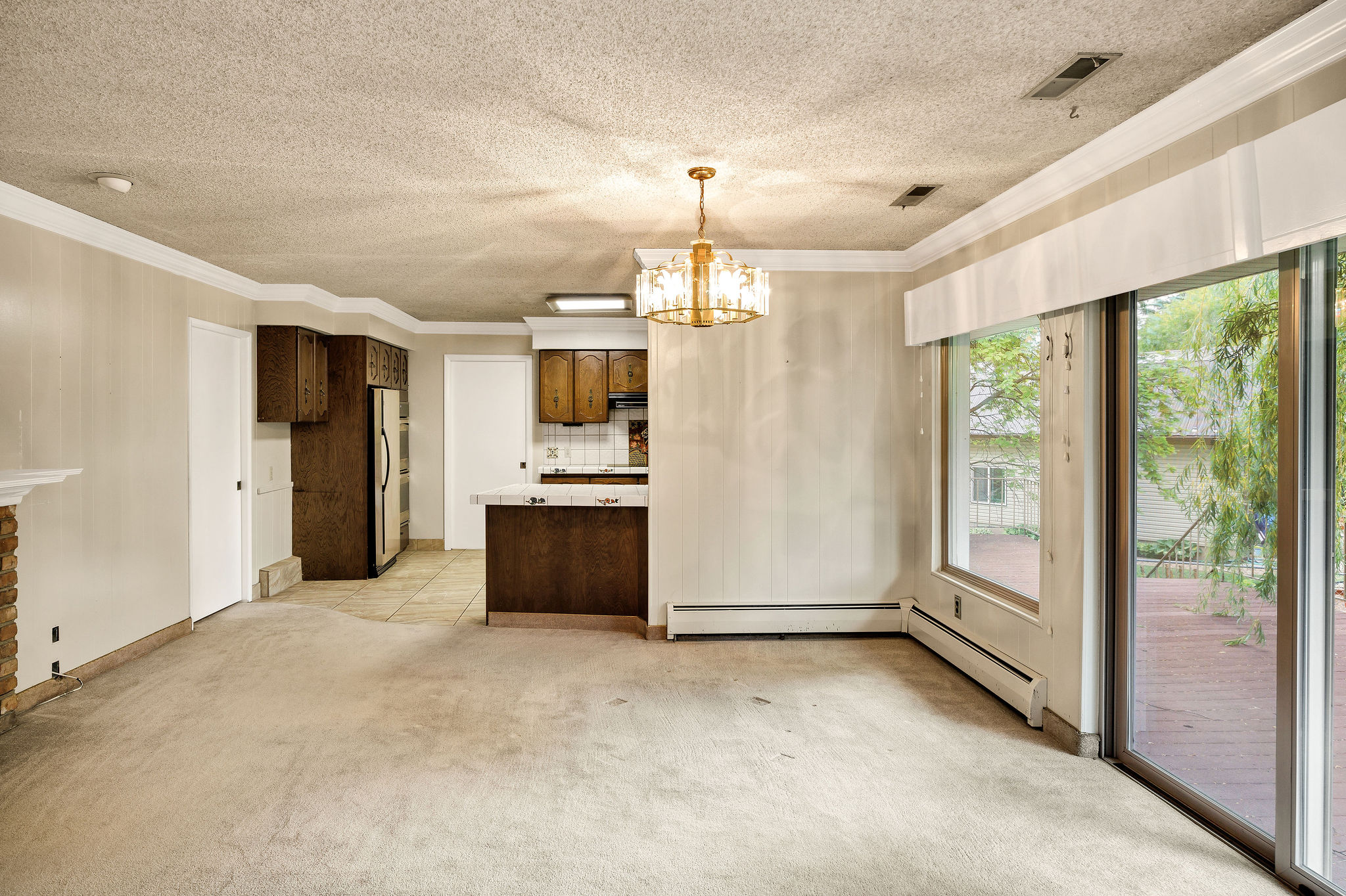 Spacious living area featuring a stone-clad fireplace and sliding glass doors opening to an outdoor deck