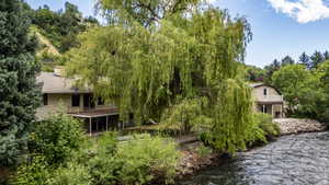 Riverside property featuring a multi-level house with a covered lower deck and an upper-level balcony