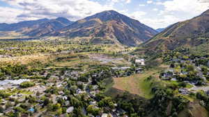 Mountainous landscape featuring a residential area with varied rooflines and surrounding green spaces