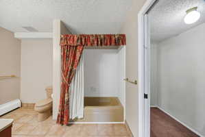 Bathroom featuring a built-in tub, tiled flooring, and a flush-mount ceiling light