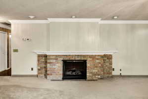 Brick fireplace with a black metal screen, a white mantel, and crown molding