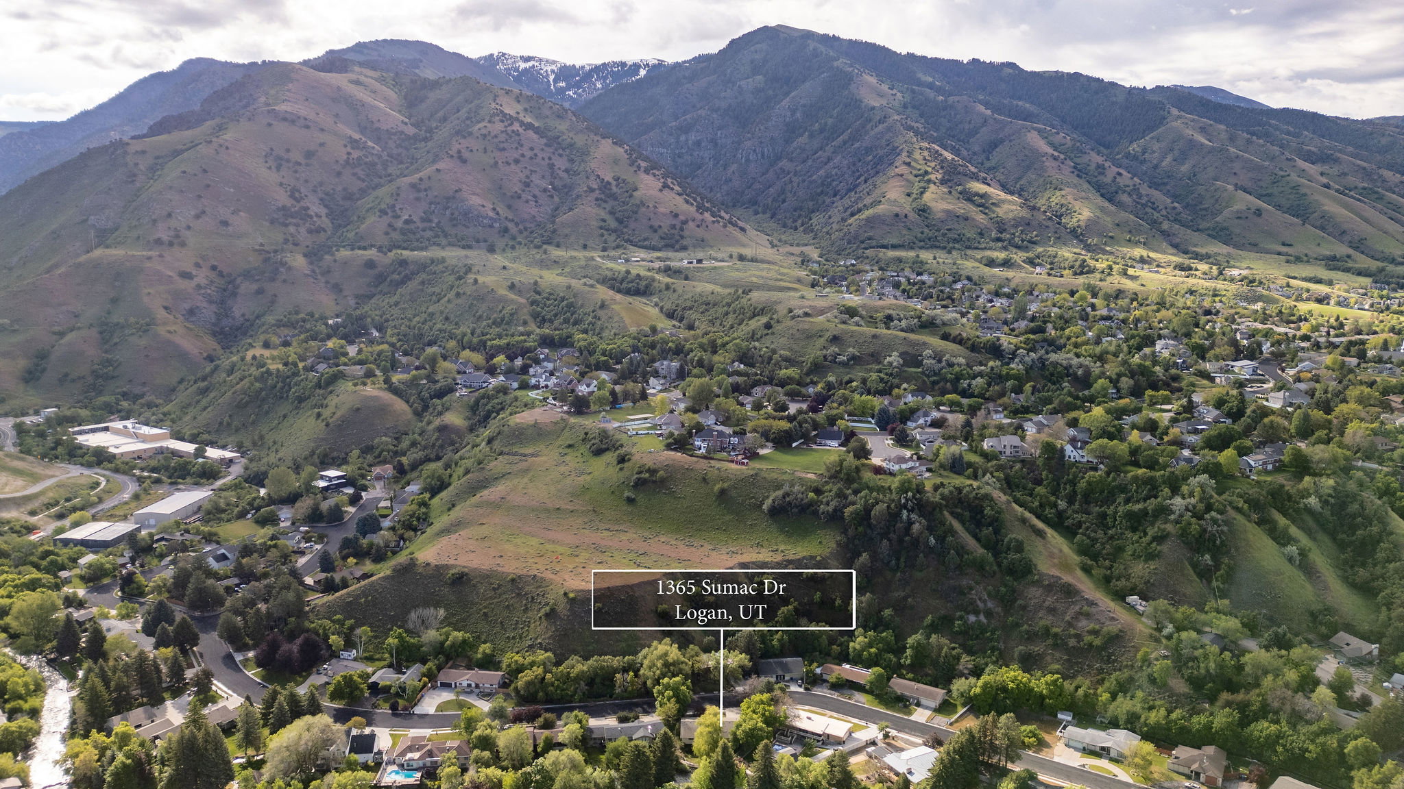 Aerial perspective showcasing a residential neighborhood nestled within a mountainous landscape