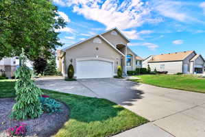 Stucco exterior property featuring a two-car garage, concrete driveway, and an arched entry