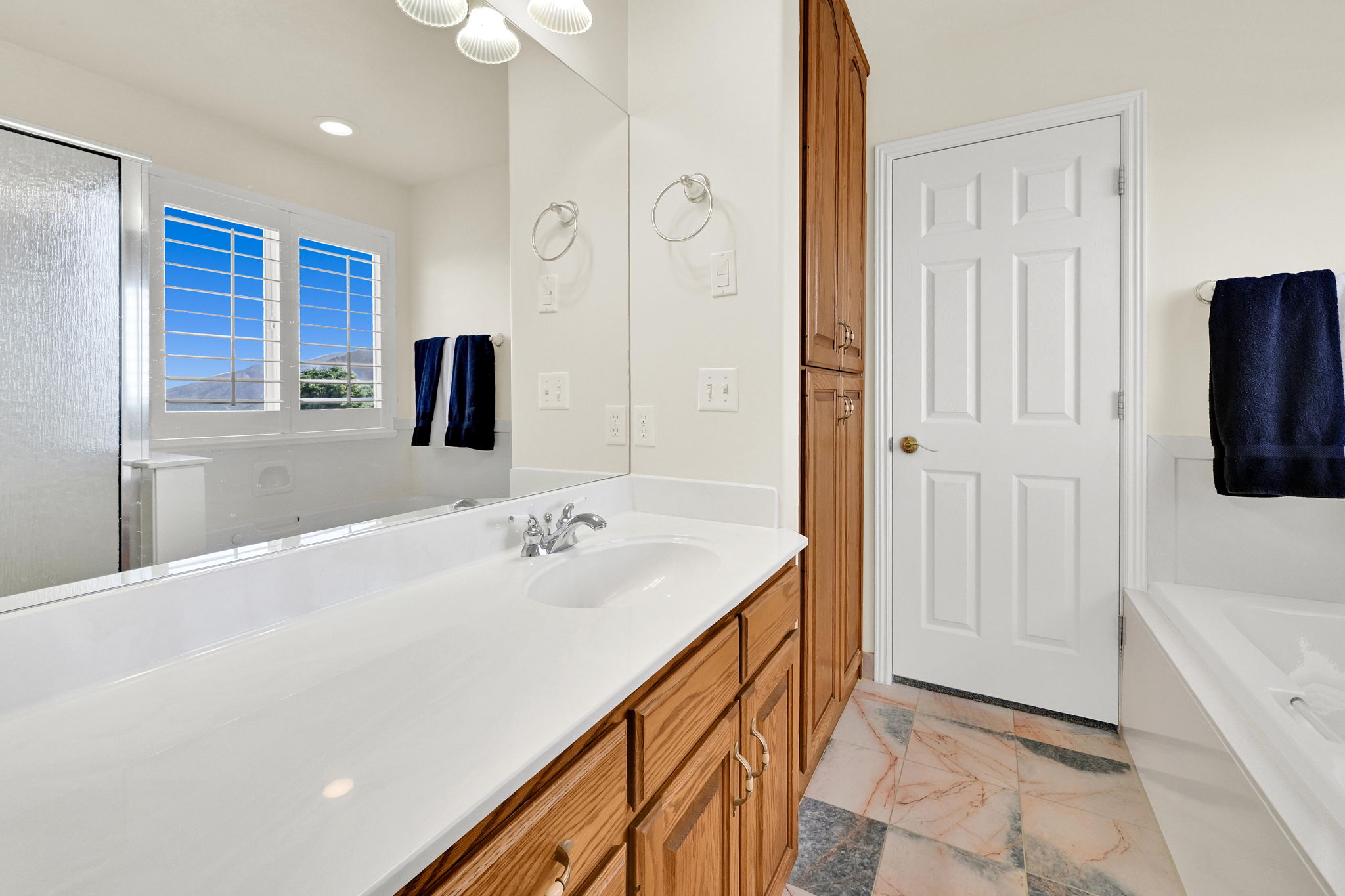 Bathroom vanity featuring a large mirror, integrated sink, and chrome faucet