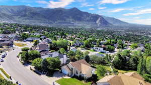 Expansive residential area with mature landscaping, surrounded by mountainous terrain