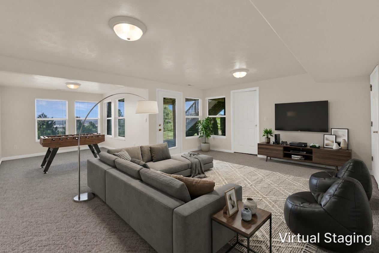 Spacious lower-level living area with light beige walls and recessed lighting