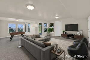 Spacious lower-level living area with light beige walls and recessed lighting