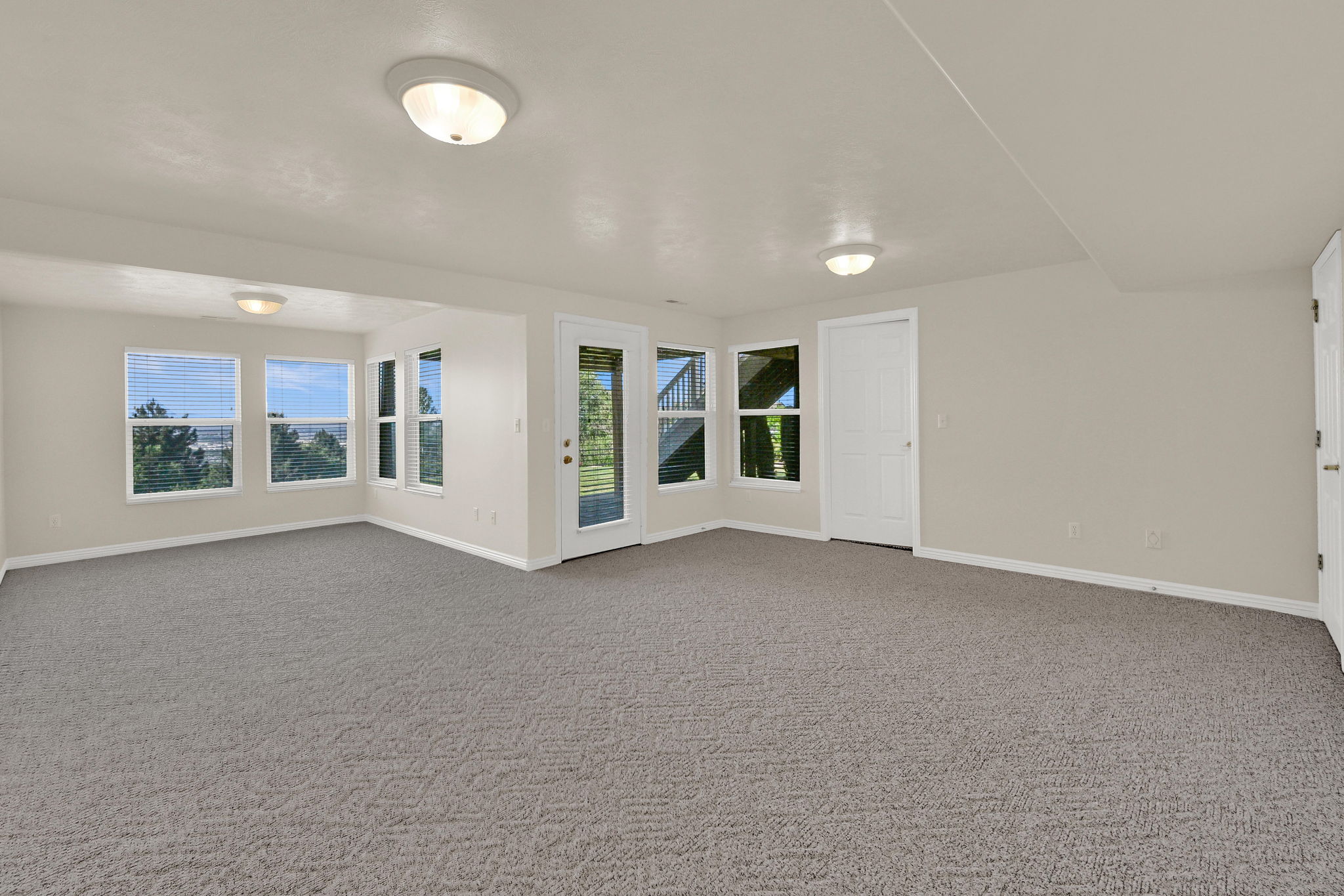 Spacious room featuring neutral carpeting and light-toned walls