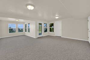 Spacious room featuring neutral carpeting and light-toned walls