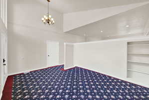 Vaulted ceiling with an overhead chandelier and recessed lighting
