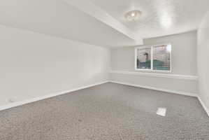 Carpeted interior space featuring neutral wall tones, a recessed window with horizontal blinds, overhead flush mount lighting, and a partial decorative chair rail