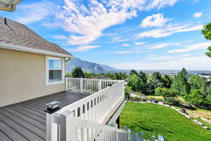 Elevated outdoor deck featuring composite decking, white railing, and a mounted solar light