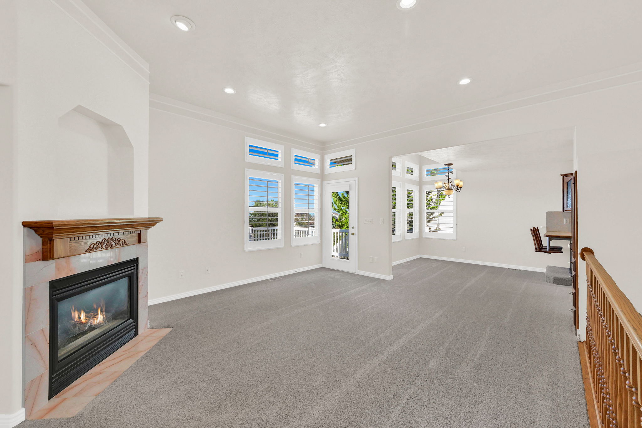 Living area featuring a gas fireplace with a marble surround and wood mantel, recessed lighting, and crown molding