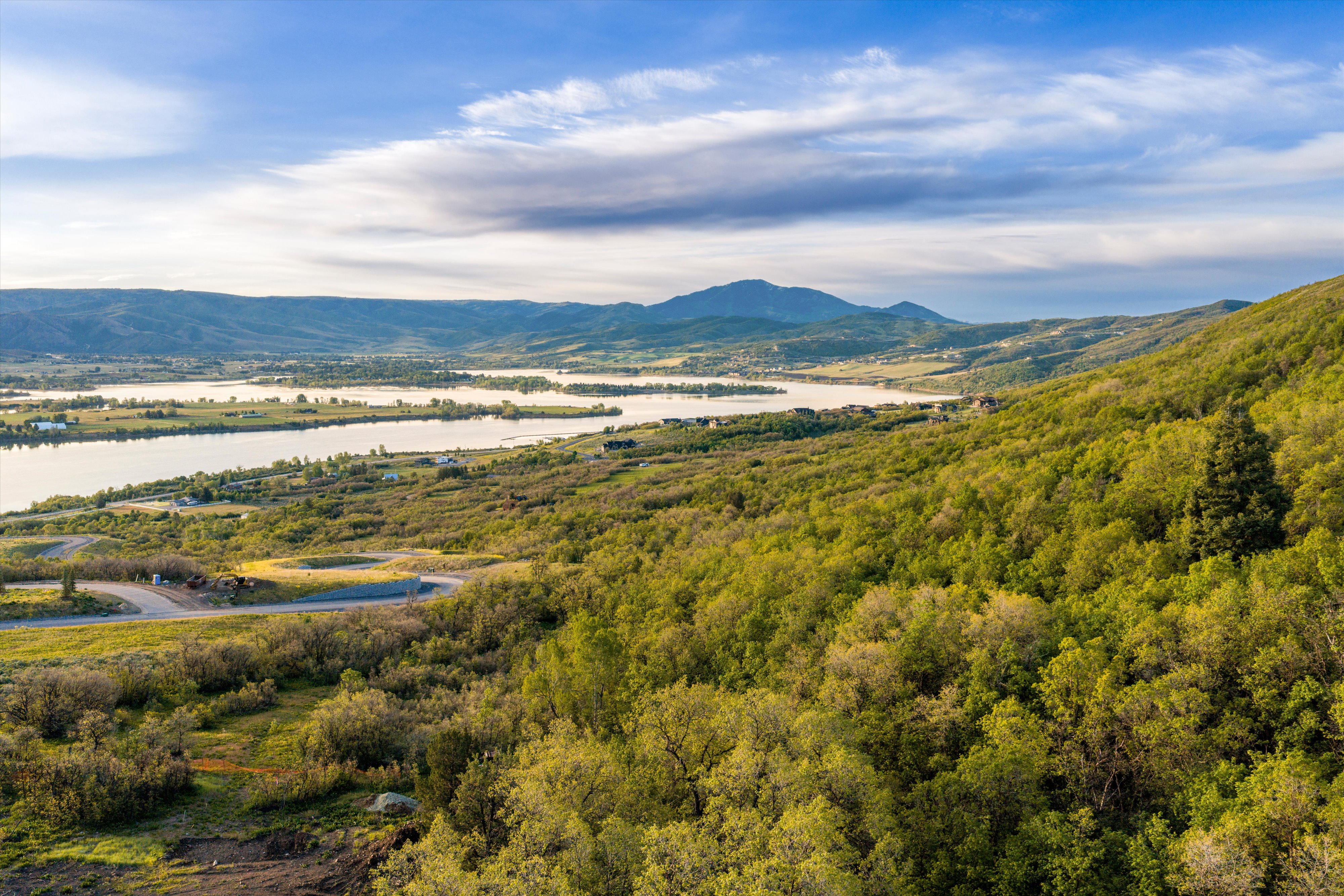Expansive mountain and lake scenery featuring lush green foliage