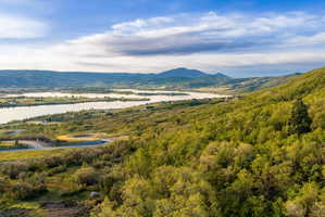 Expansive mountain and lake scenery featuring lush green foliage