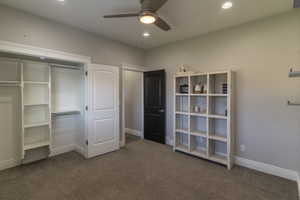 Bedroom featuring a built-in closet organization system, plush carpet flooring, recessed lighting, a ceiling fan, and white baseboards