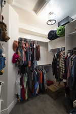 Built-in closet system featuring multiple hanging rods, overhead shelving, recessed lighting, and a semi-flush mount ceiling fixture