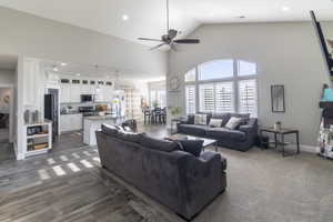 Open-concept living area featuring vaulted ceilings, recessed lighting, and a ceiling fan
