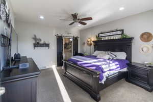 Spacious bedroom featuring neutral wall tones, recessed lighting, and a ceiling fan