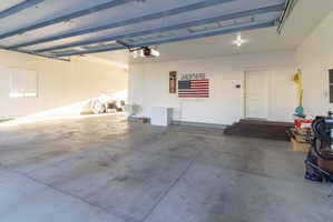 Spacious garage with concrete flooring, overhead lighting, and white walls
