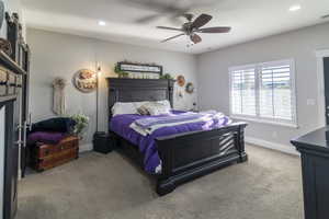 Carpeted room featuring light gray walls, a ceiling fan with integrated lighting, recessed lighting, and a large window with white plantation shutters
