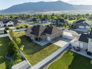 Single-story residence featuring a tan stucco and stone facade, dark shingle roof, and an attached two-car garage