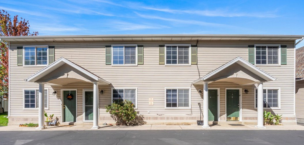 Two-story duplex with vinyl siding and individual covered entryways