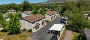 Multi-building property featuring light gray siding, brown shingle roofing, and covered entryways