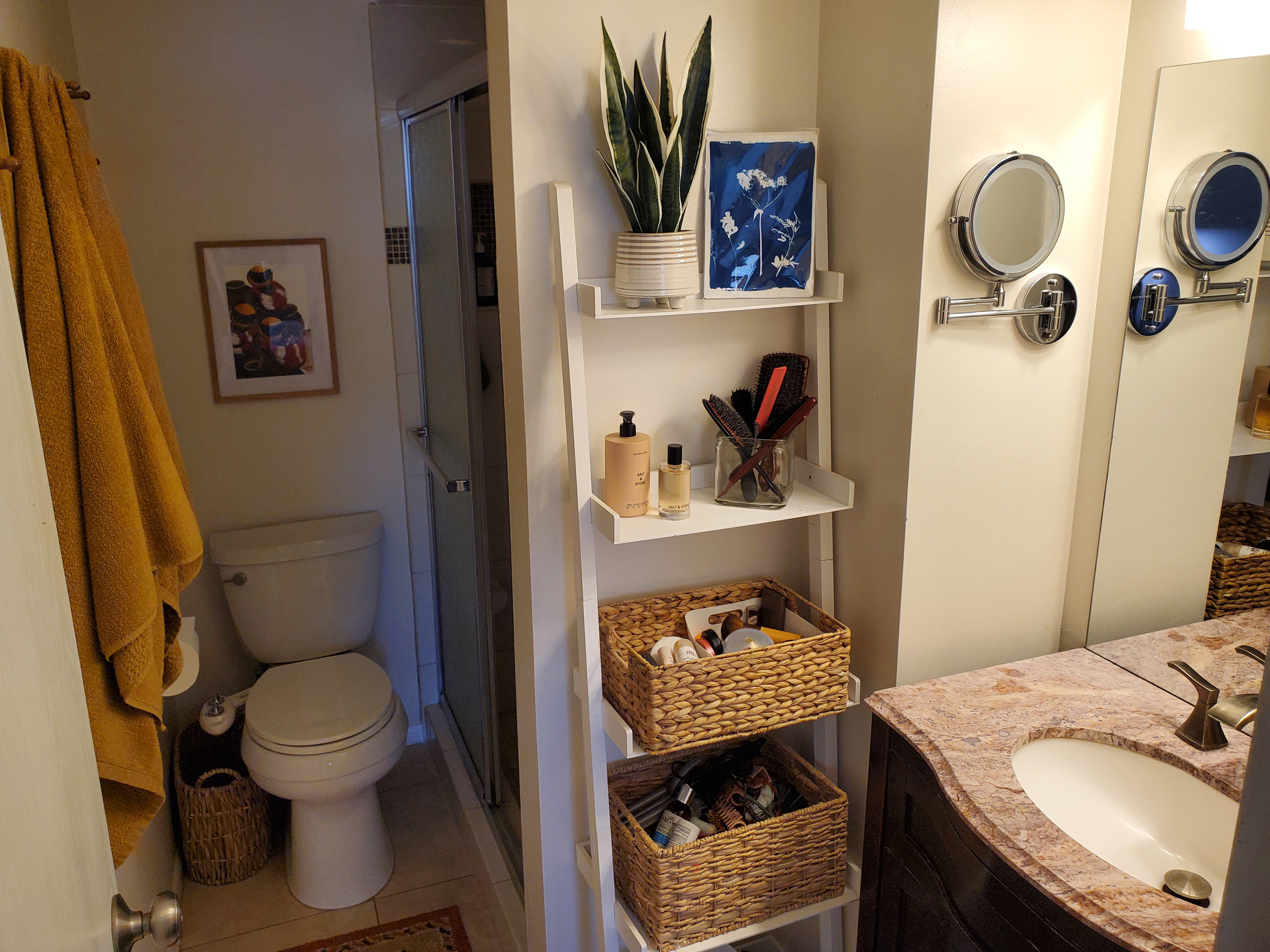 Bathroom featuring a shower enclosure, white toilet, and a vanity with a contoured countertop